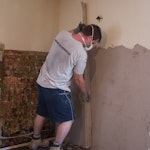 Den Putz mit einem Richtscheit glätten